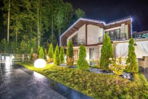 a house with a garden in the rain at night at Karpatski Hotel & Spa in Bukovel