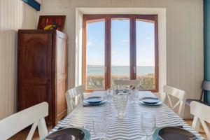 jadalnia ze stołem i dużym oknem w obiekcie Villa des Roches - vue mer exceptionnelle w mieście Clohars-Carnoët +16 zdjęć