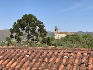 a roof of a building with a tree in the background at Pousada Horto dos Contos in Ouro Preto