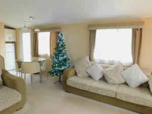 a living room with a christmas tree and a couch at Clwyd 6 in Borth