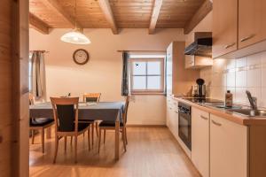 a kitchen with a table and a dining room at Ladinser Hof Sattelkammer in Castelrotto