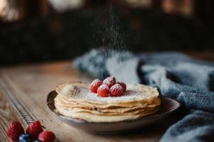 a plate of pancakes with berries on a table at Gut Berg Naturhotel in Sankt Johann im Pongau