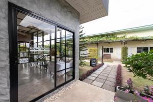 a glass door of a building with a patio at บ้านสวนวารินทร์ รีสอร์ท in Pak Chong