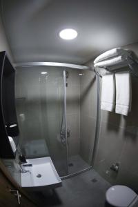 a bathroom with a shower with a sink and a toilet at Fanus Suites Karaköy in Istanbul