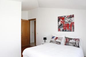 カスカイスにあるWondrous Terrace Apartment in Cascais Centerの白いベッドと壁に絵画が飾られたベッドルーム1室