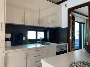 a kitchen with white cabinets and a sink at FLH Cascais Charming Old Town in Cascais