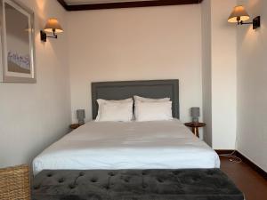 a bedroom with a large white bed with two pillows at FLH Cascais Charming Old Town in Cascais