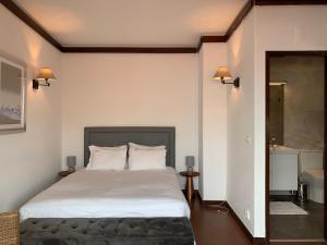 a bedroom with a large white bed and a bathroom at FLH Cascais Charming Old Town in Cascais +38 photos