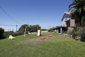 a yard with a swing set and frisbees on the grass at Mira Guincho house with sea view and garden, Cascais in Alcabideche