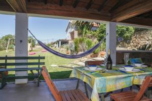 un patio con tavolo, sedie e amaca di Mira Guincho house with sea view and garden, Cascais a Alcabideche
