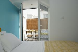 a bedroom with a bed and a balcony with a table at A piece of paradise in the heart of Cascais in Cascais