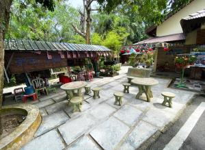 um pátio com mesas e bancos em frente a uma loja em Sabak Awor Resort em Muar