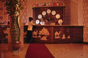 a man and a woman standing behind a counter with clocks at Mixt Royal Palace in Samarkand