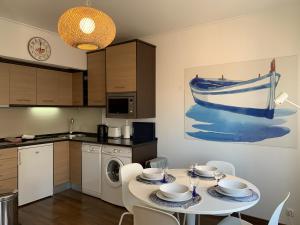a kitchen with a table and a boat on the wall at Relaxing apartment in the heart of Cascais in Cascais