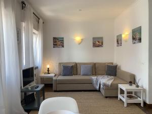 a living room with a couch and a tv at Relaxing apartment in the heart of Cascais in Cascais