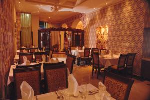 a dining room with tables and chairs in a restaurant at Mixt Royal Palace in Samarkand