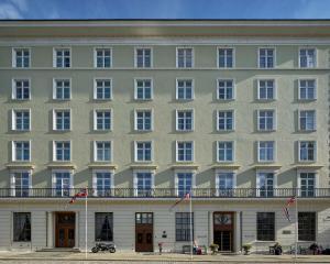 a large white building with flags in front of it at Grand Hotel Terminus in Bergen