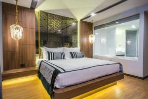 a bedroom with a bed and a window and lights at Stay with Nimman Chiang Mai - SHA Extra Plus in Chiang Mai