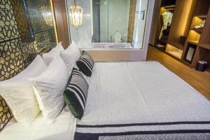 a bedroom with a bed with pillows at Stay with Nimman Chiang Mai - SHA Extra Plus in Chiang Mai