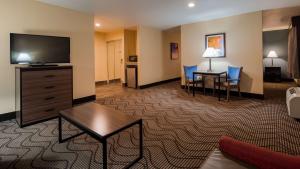 ein Hotelzimmer mit einem Flachbild-TV und einem Wohnzimmer in der Unterkunft Best Western Plus Heritage Inn in Stockton