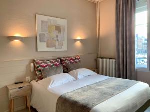 Un pat sau paturi într-o cameră la Best Western Hôtel Des Voyageurs