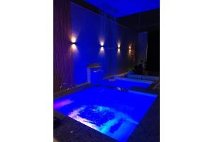 uma casa de banho com duas piscinas jacuzzi com iluminação azul em RESIDENCIA CIDADE VERDE 7 em Maringá