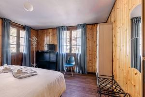 a bedroom with a bed and a blue chair at Hotel Dufour in Macugnaga