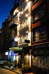 a tall building with a restaurant in front of it at night at Fanus Suites Karaköy in Istanbul