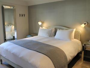 a bedroom with a large bed with white sheets and pillows at The Ship Inn in Rye