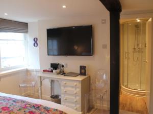 a bedroom with a tv on the wall and a dresser at The Ship Inn in Rye