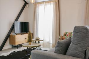 a living room with a couch and a tv at EL CIELO DE CÁCERES in Cáceres