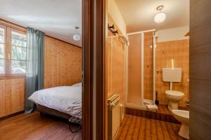 a bathroom with a bed a toilet and a sink at Hotel Dufour in Macugnaga