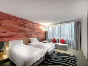 Кровать или кровати в номере Novotel Sharjah Expo Centre