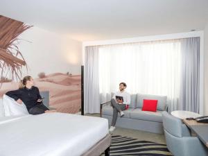Кровать или кровати в номере Novotel Sharjah Expo Centre