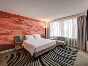 Кровать или кровати в номере Novotel Sharjah Expo Centre