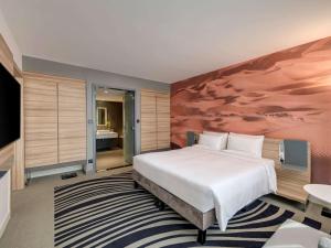 Кровать или кровати в номере Novotel Sharjah Expo Centre