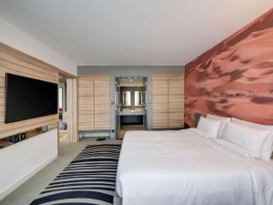Кровать или кровати в номере Novotel Sharjah Expo Centre