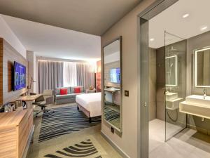 Кровать или кровати в номере Novotel Sharjah Expo Centre