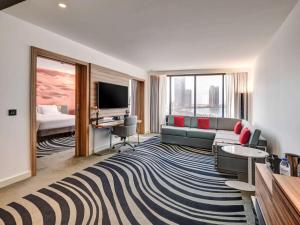 a living room with a couch and a television at Novotel Sharjah Expo Centre in Sharjah
