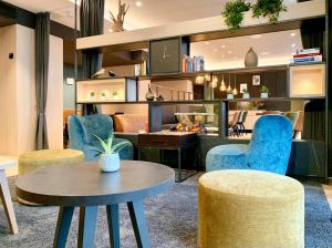 a living room with blue chairs and a table at zeitwohnhaus SUITE-HOTEL & SERVICED APARTMENTS in Erlangen