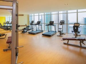 a gym with a bunch of treadmills and machines at Pullman Sharjah in Sharjah