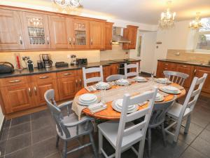 a kitchen with a dining room table and chairs at Yr Hen Ysgol, The Old School in Porthmadog