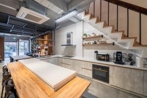 eine Küche mit einem Tisch und einer Treppe darin in der Unterkunft De Provintia Straat B&B in Tainan