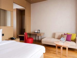 Habitación de hotel con cama, sofá y mesa en ibis Styles Krasnaya Polyana, en Estosadok