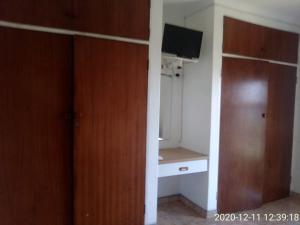a room with a closet and a desk and a television at Unit 6 Villa Marina in Hibberdene