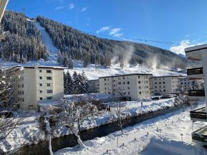 uma cidade coberta de neve com edifícios e uma montanha em Sehr zentral beim Jakobshorn, Bolgen, Skischule, Skivermietung, Bahnhof, Supermarkt, Restaurants, WIFI, Netflix und voll ausgestattet - Fewo Bolgen em Davos