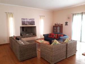 a living room with three chairs and a couch at Elkes Guesthouse in Nieu-Bethesda