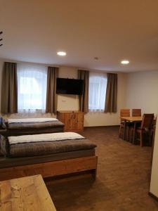 1 dormitorio con 2 camas, escritorio y TV en Hansmayrgut, en Waizenkirchen