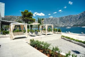 a patio area with chairs and a beach at Blue Kotor Bay Premium Spa Resort in Kotor