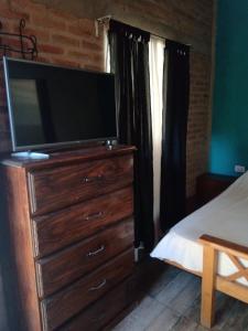a bedroom with a dresser with a flat screen tv on it at MONOAMBIENTES LOS SAUCES in Mina Clavero +41 photos